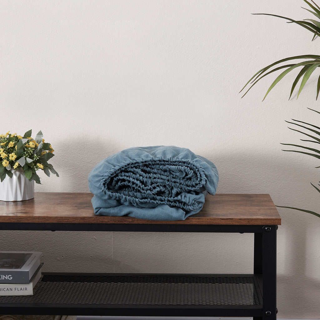 French Blue Linen Fitted Sheet Folded on a Bench