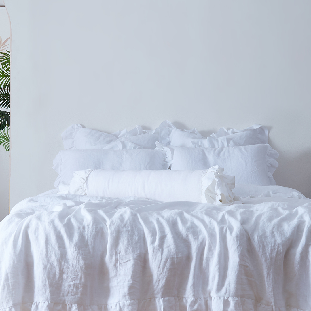 Optic White Linen Bolster Cushion on Bed with Ruffle Hem