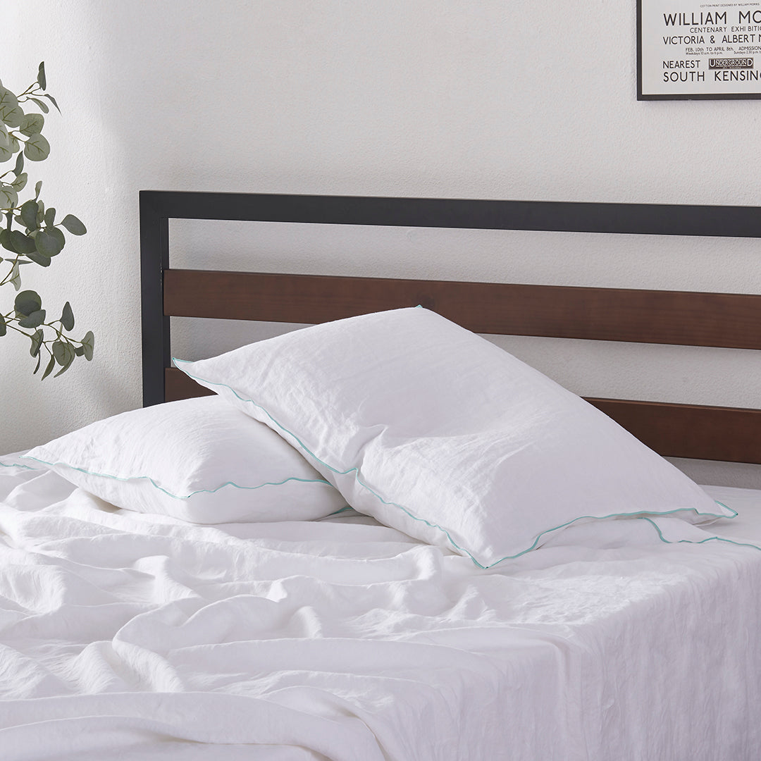 Pillows with Aqua Edge Embroidered White Linen Pillowcases on Bed