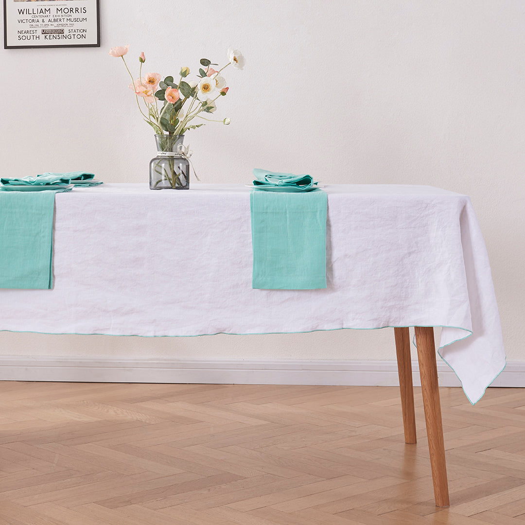 White Linen Tablecloth with Embroidered Aqua Green Edge on Table