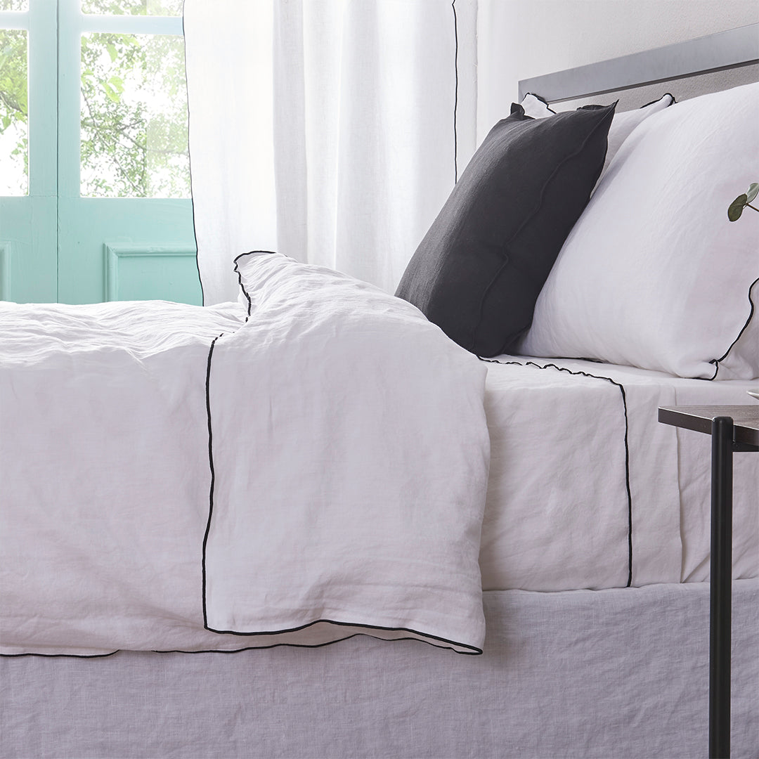 White Linen Duvet Cover with Black Embroidered Edge on Bed