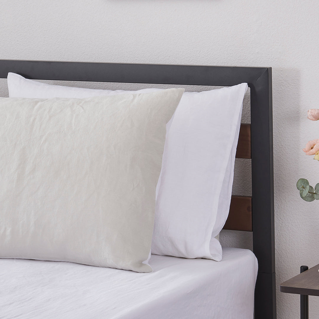 A pair of cool grey and white 100% linen two tone pillowcases arranged on a bed