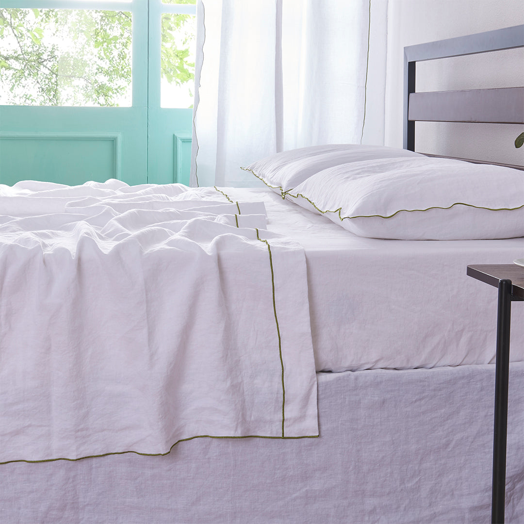 White Linen Flat Sheet with Leek Green Embroidered Edge on Bed