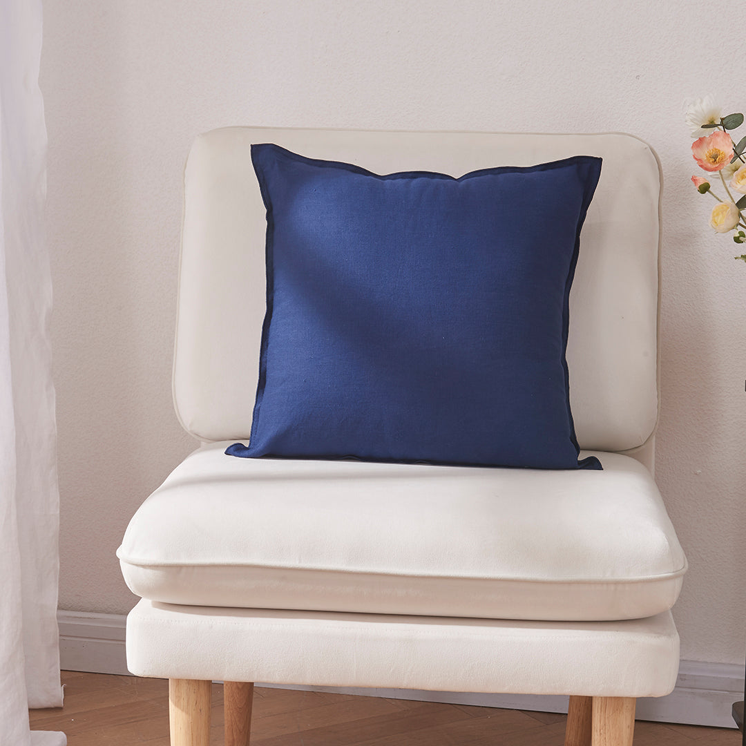 An indigo blue 100% linen edge embroidery cushion on an accent chair