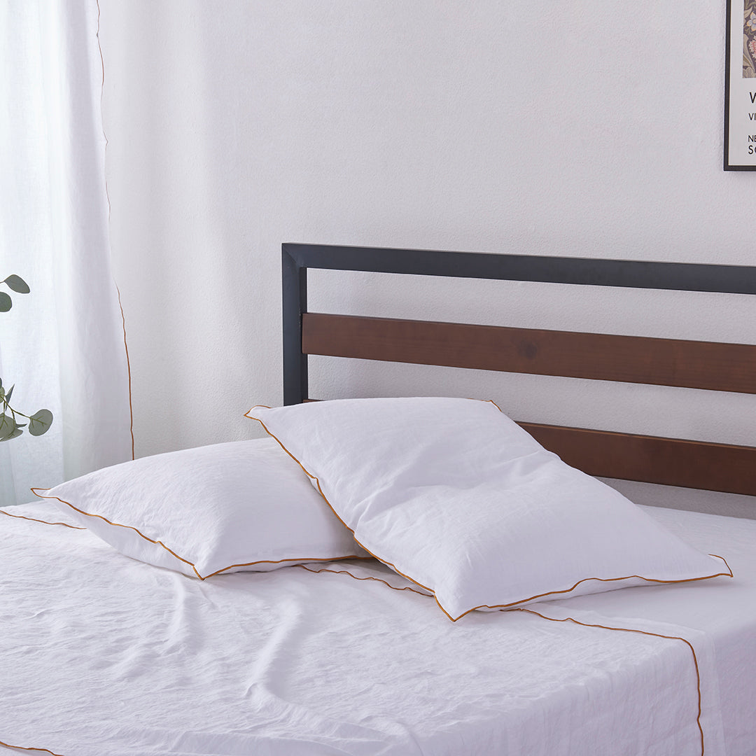 Cooling White Linen Pillowcases with Mustard Yellow Embroidered Edge on Bed