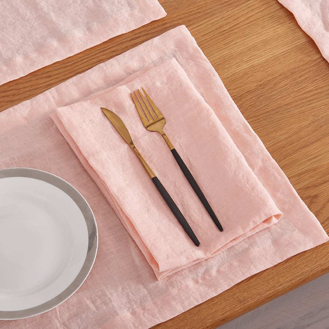 100% linen peach table napkin folded under cutlery