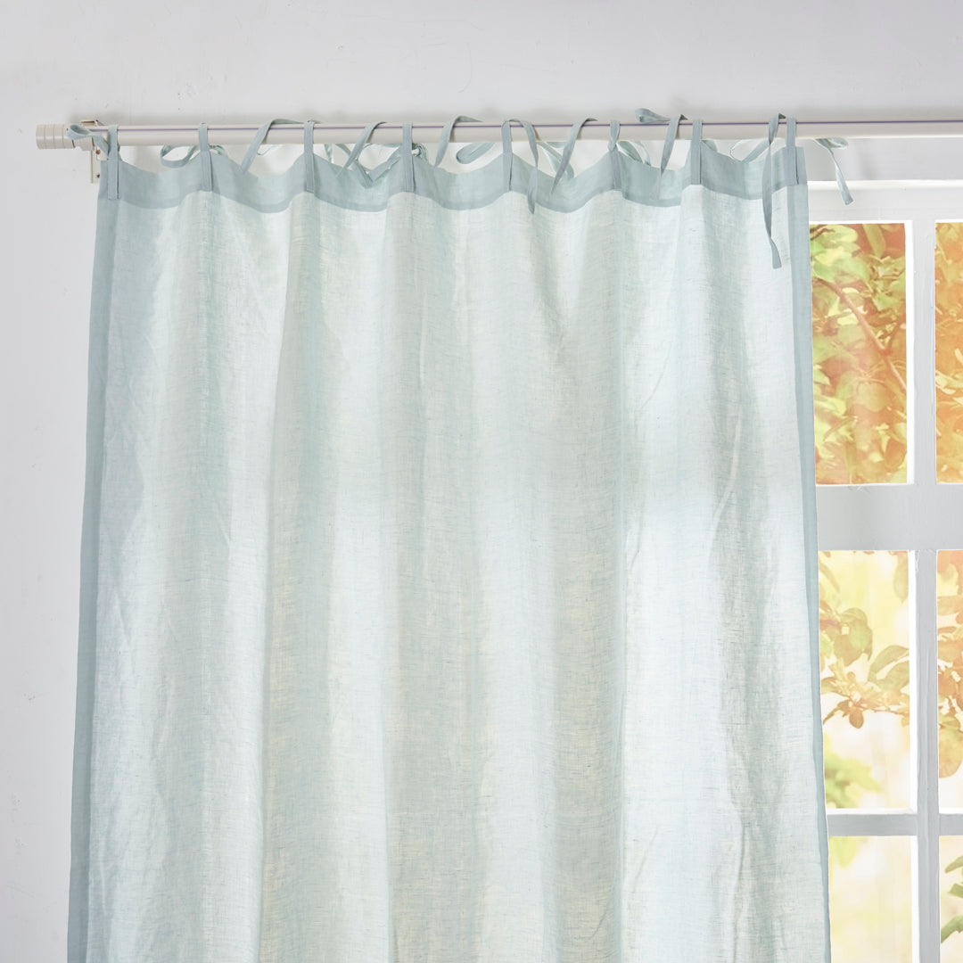 Close-up of the top of pale blue linen drapery