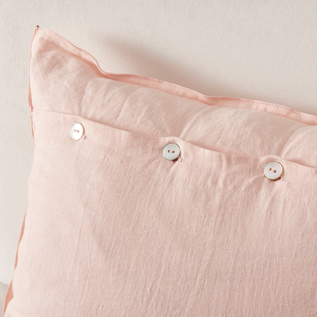 Close-up detail of 100% linen peach embroidery cushion cover with mother of pearl buttons