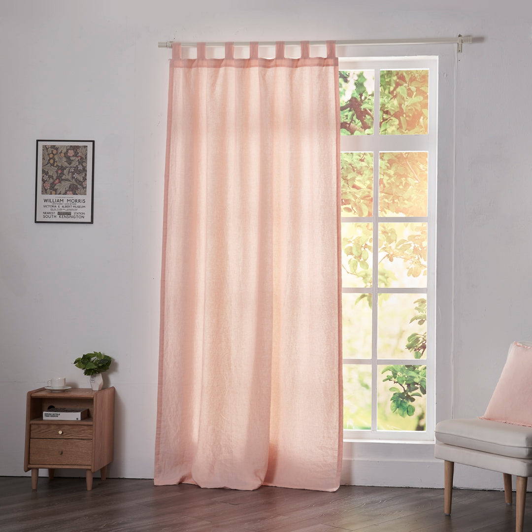 Peach linen drapery with tab tops hanging over windows