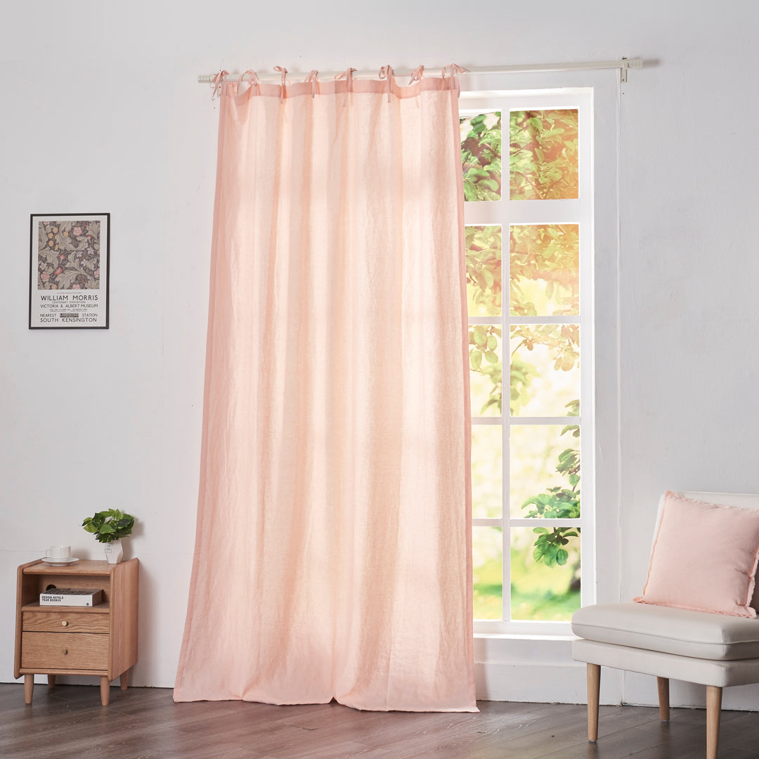 Peach linen drapery with tie tops hanging over windows