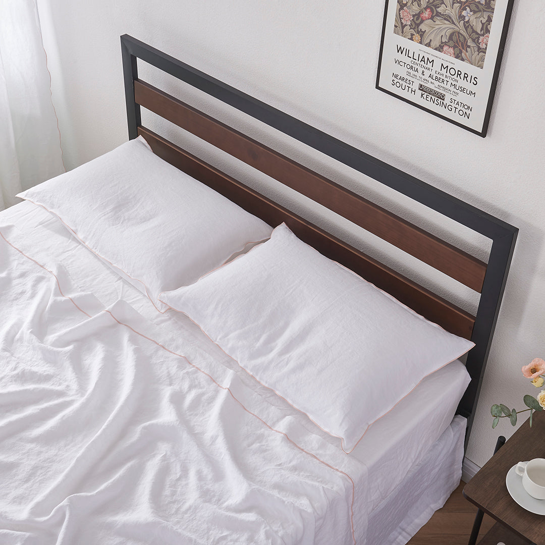 Top angle of a pair of 100% linen pillowcases with edge embroidery in peach
