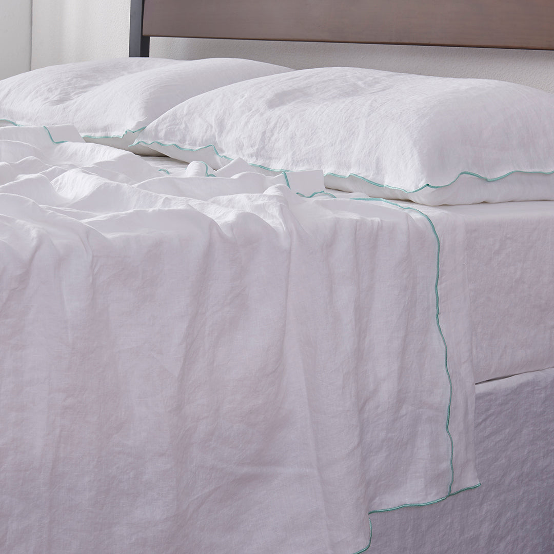 White Linen Bedsheet with Embroidered Edge on Bed