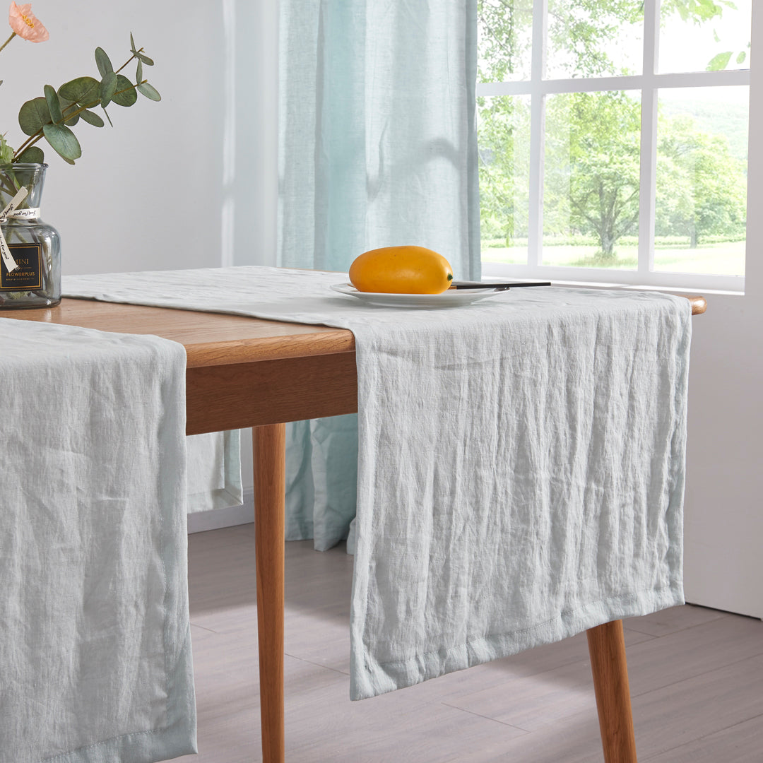 Pale Blue linen table runners draped over a wooden dining table