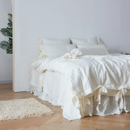 Side View Of Ivory Linen Bolster Pillow with Bow Ties on Bed