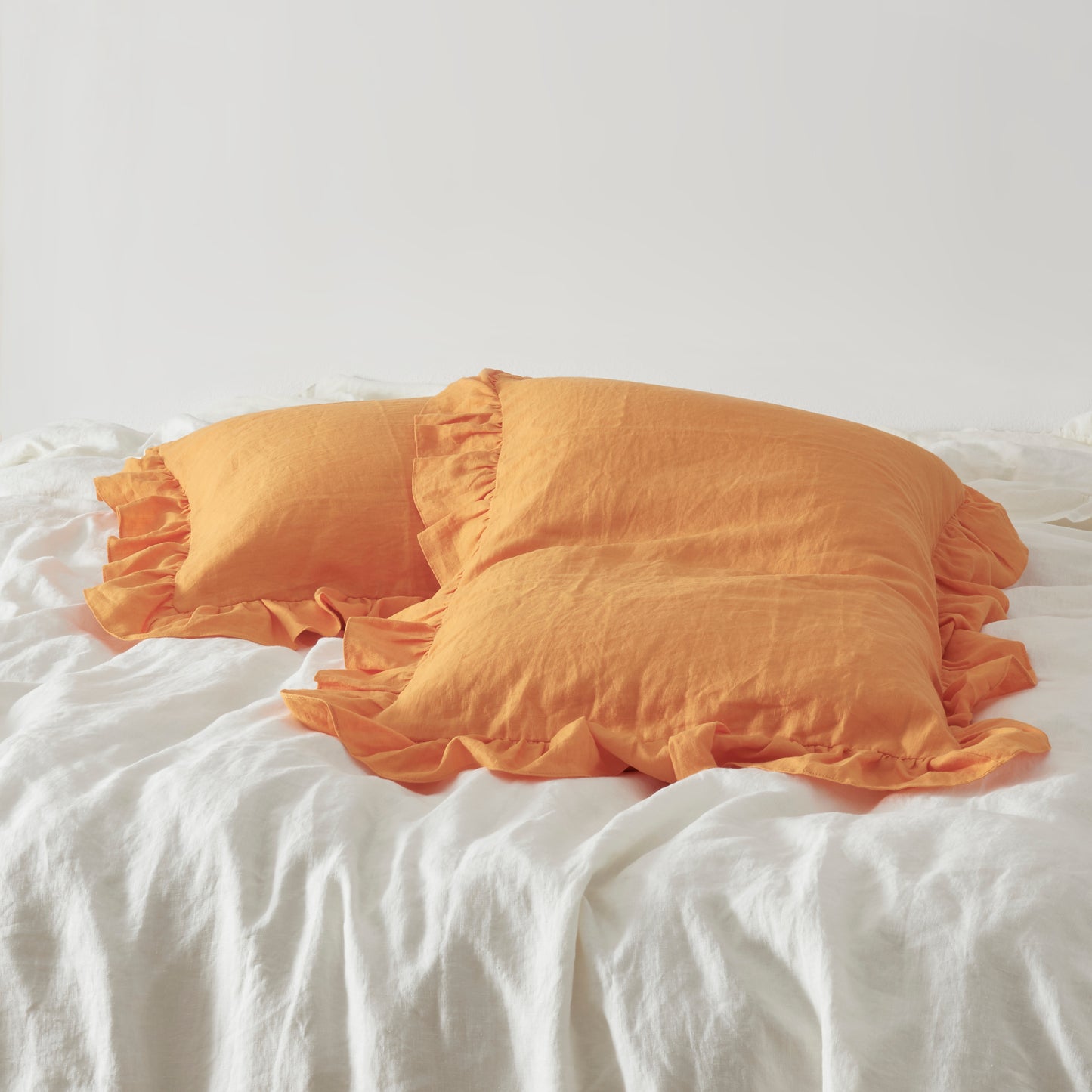 Tangelo Orange Linen Pillowcases with Ruffle Hem on Bed