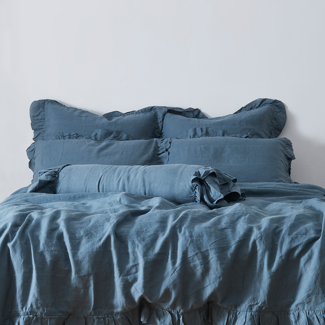 French Blue Linen Ruffle Bolster Cushion on Bed