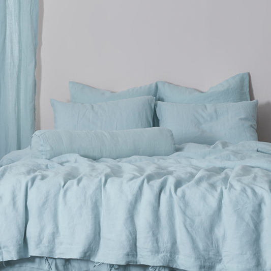 Pale Blue Buttoned Linen Bolster Cushion on Bed