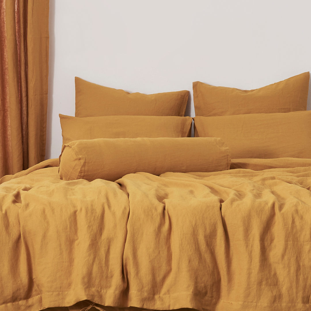 Mustard Yellow Buttoned Linen Bolster Cushion on Bed