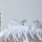 Optic White Linen Bow Ties Bolster Pillow on Bed