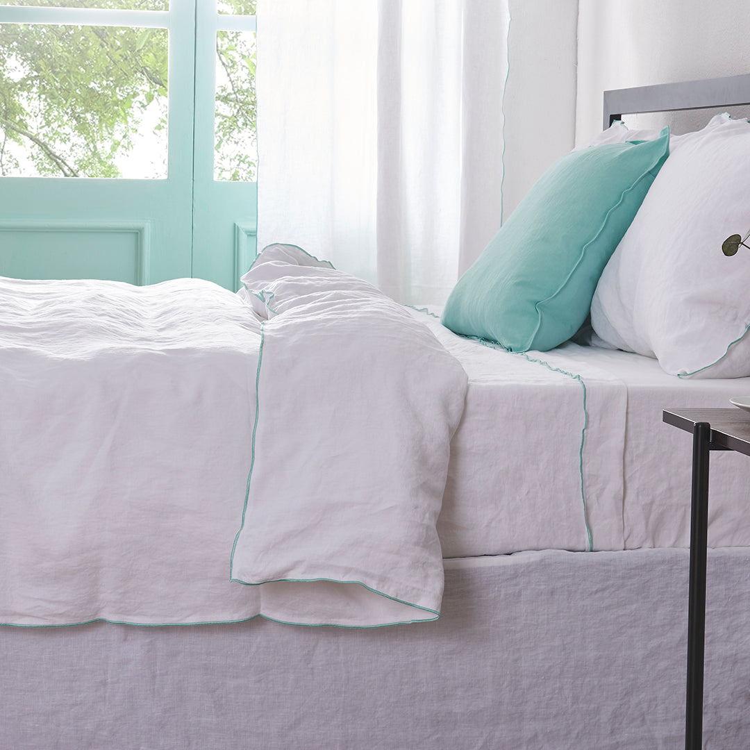 White Linen Duvet Cover with Embroidered Aqua Edge on Bed