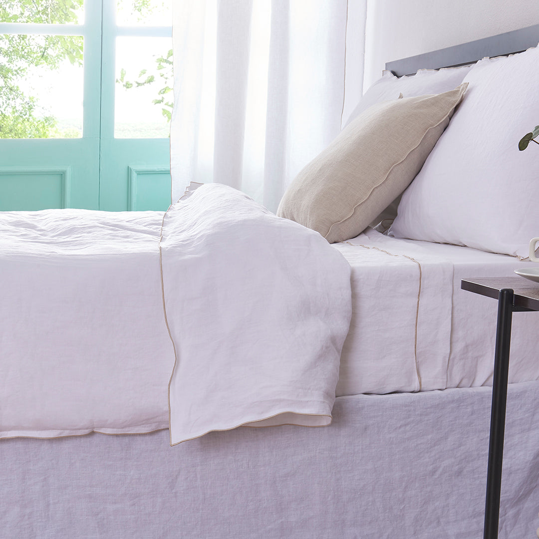 White Linen Duvet Cover with Beige Embroidered Edge on Bed