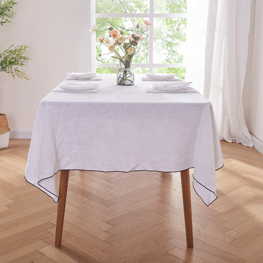 White Linen Tablecloth with Black Embroidered Edge on Dining Table