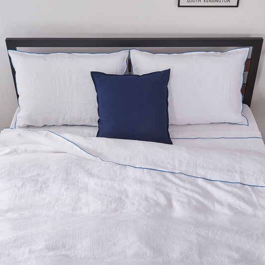 White Linen Duvet Cover with Brilliant Blue Embroidered Edge on Bed