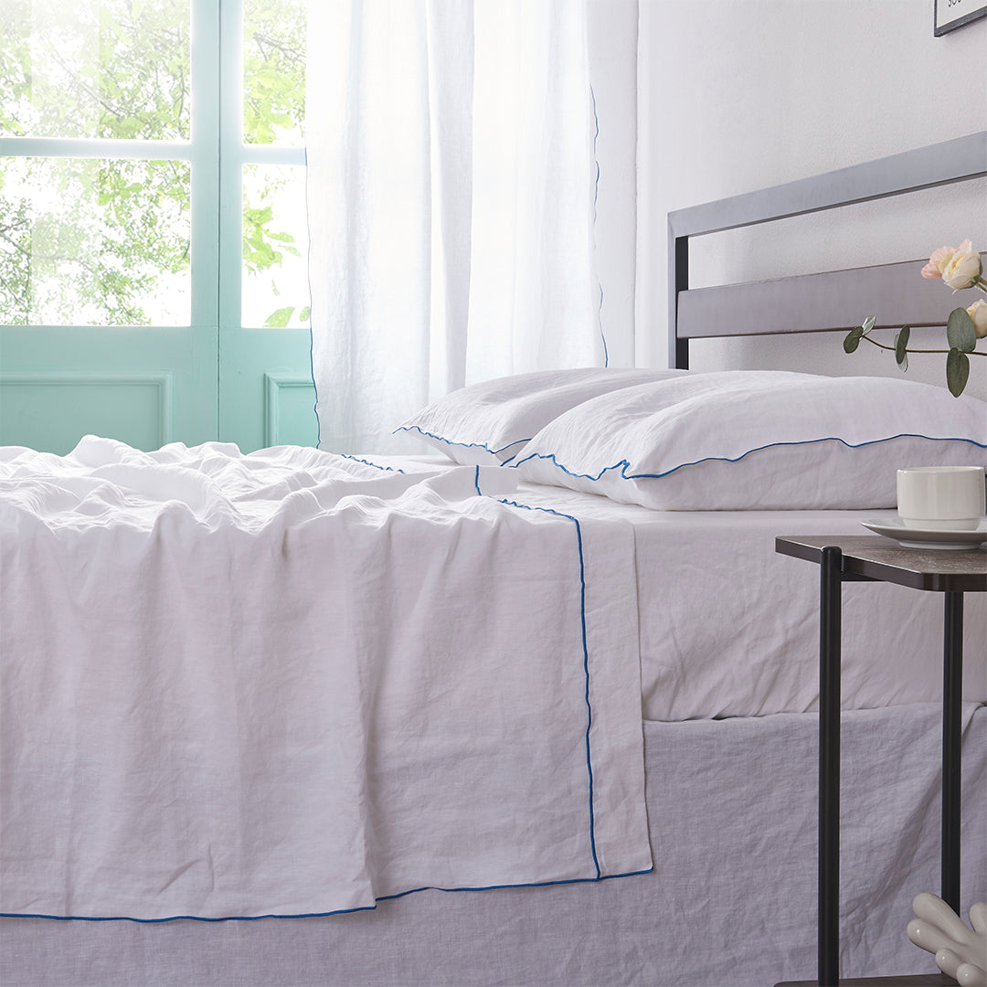 100% Linen White Flat Sheet with Brilliant Blue Embroidered Edge on Bed