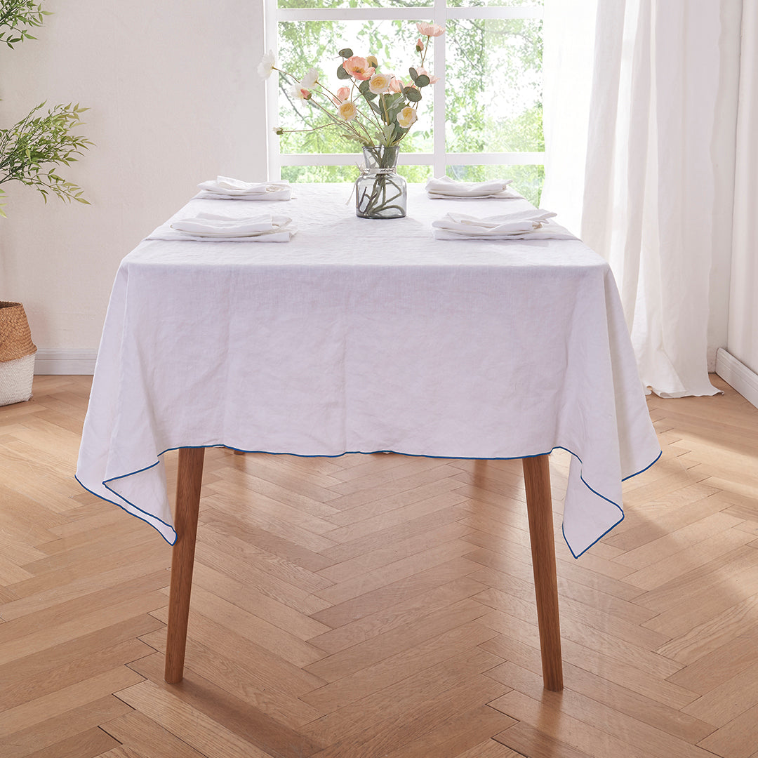 White Linen Tablecloth with Brilliant Blue Embroidered Edge on Dining Table
