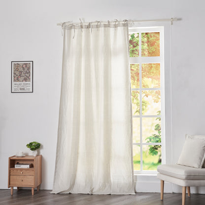 Cool gray linen drapery with tie tops hanging over windows