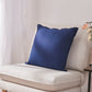 Side angle of an indigo blue 100% linen edge embroidery cushion on an accent chair