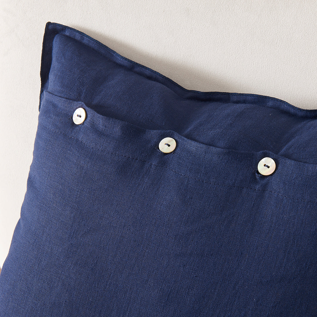 Close-up detail of 100% linen indigo blue embroidery cushion cover with mother of pearl buttons