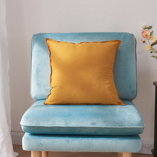 A mustard 100% linen edge embroidery cushion on an accent chair