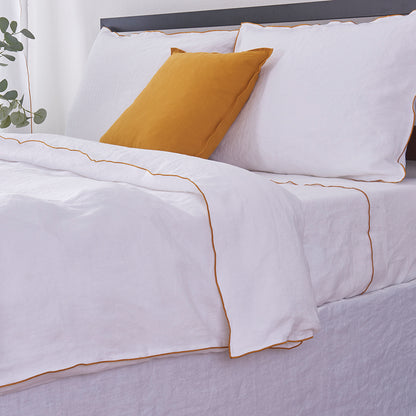 White Linen Duvet Cover with Mustard Yellow Embroidered Edge on Bed