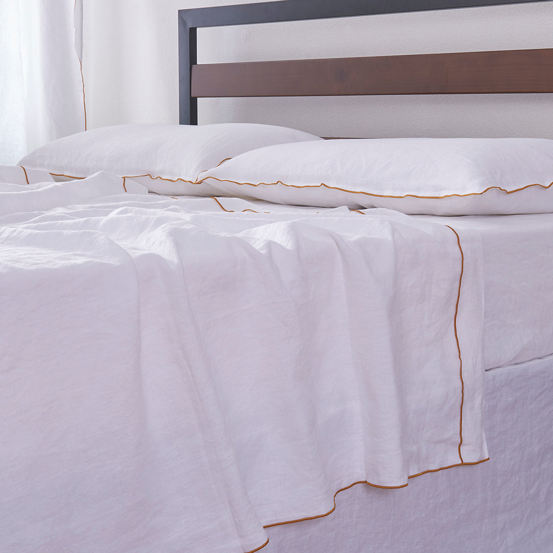 White Linen Flat Sheet with Mustard Yellow Embroidered Edge on Bed