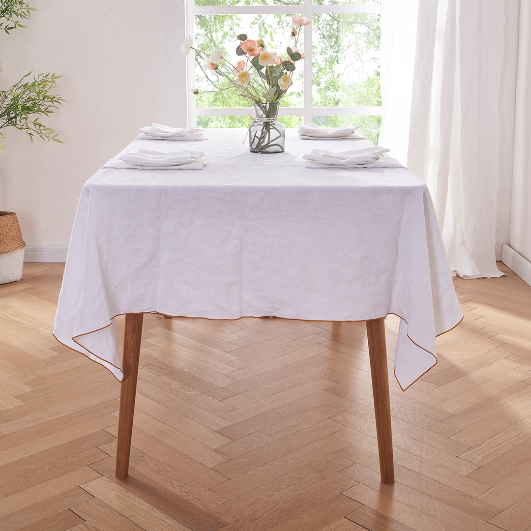 White Linen Tablecloth with Mustard Yellow Embroidered Edge on Table