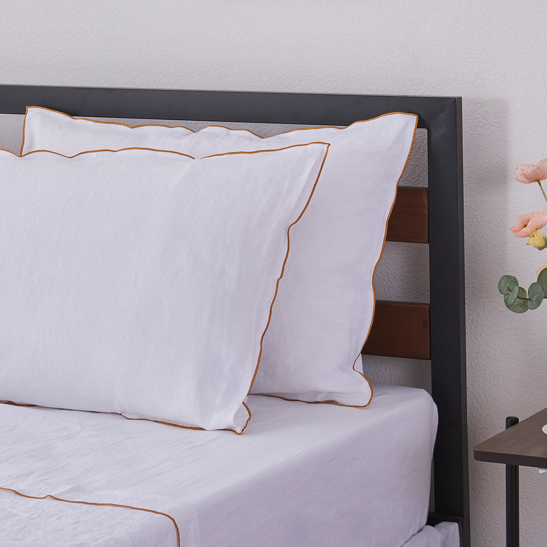 White Linen Pillowcases with Mustard Yellow Embroidered Edge on Bed