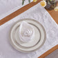 Ivory plain napkin made from 100% linen on top of a dinner plate