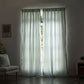 Pale blue linen drapery with cotton lining drawn closed over windows