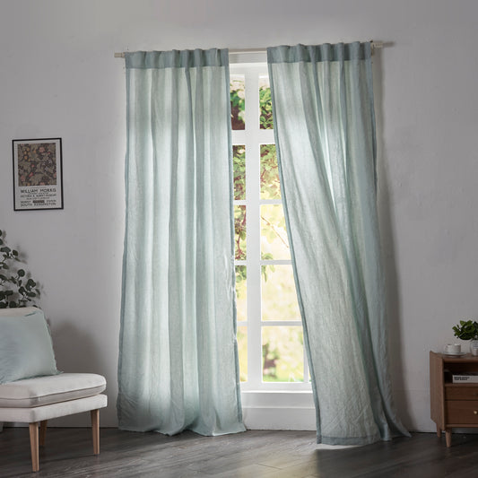 Pale blue linen drapery with cotton lining billowing over windows