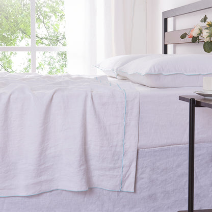 White Linen Flat Sheet with Pale Blue Embroidered Edge on Bed