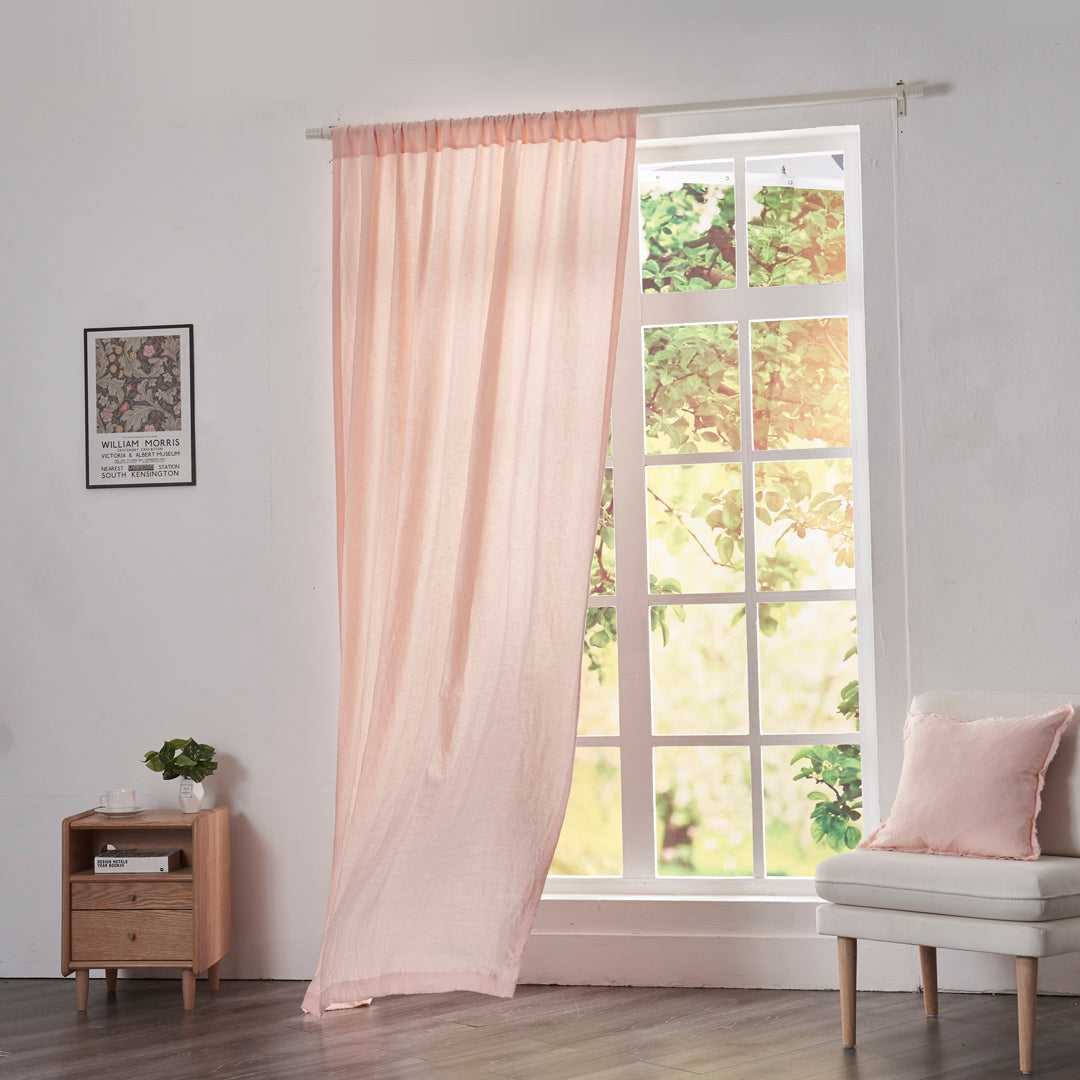 Peach linen drapery with rod pockets billowing over windows