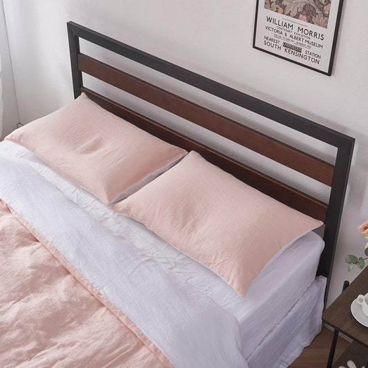 A pair of peach and white 100% linen two tone pillowcases lying flat on a bed