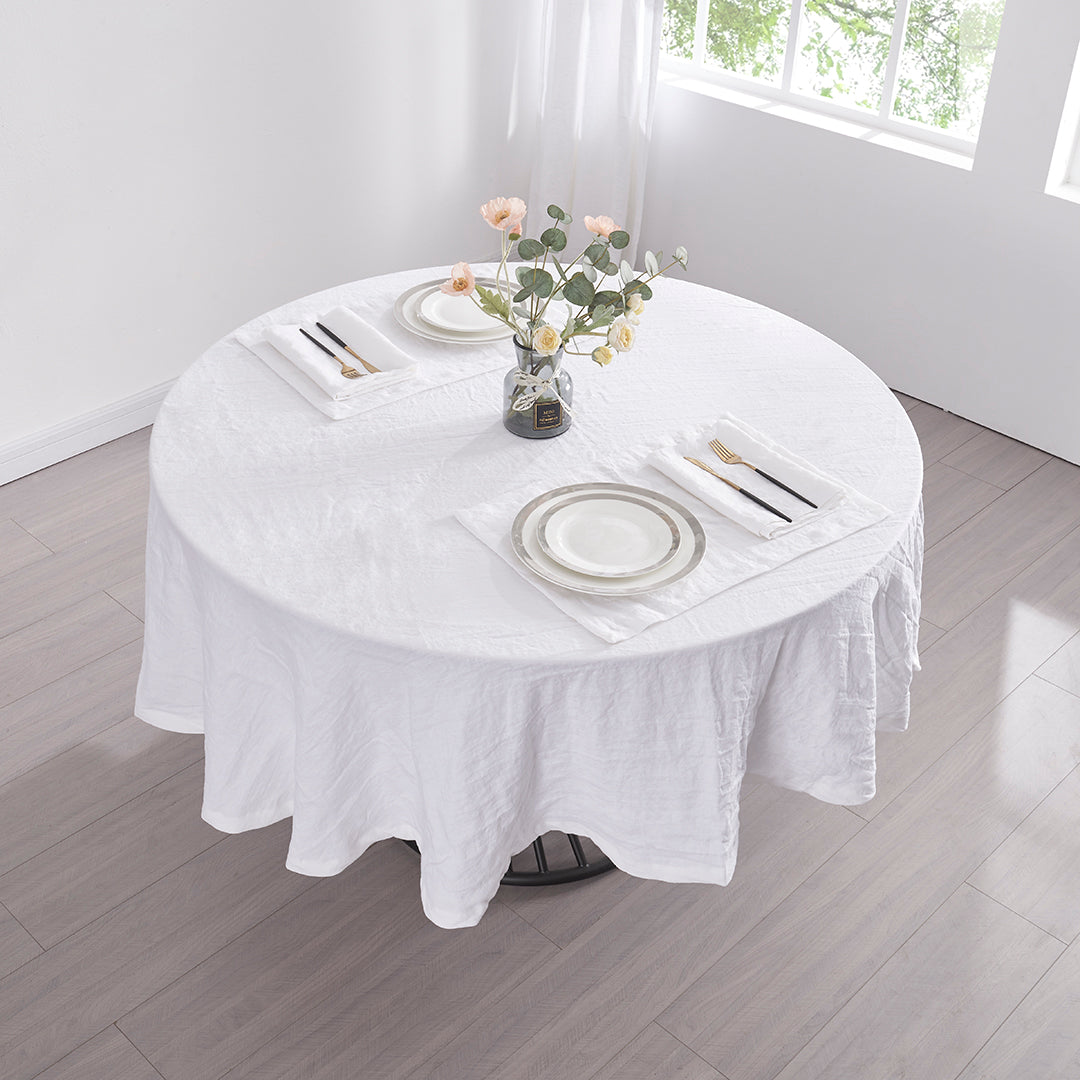 Top angle of optic white 100% linen round tablecloth draped over a round table