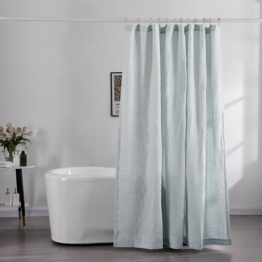 100% linen pale blue shower curtain hanging over ceramic bathtub