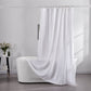 100% linen optic white shower curtain draped over ceramic bathtub