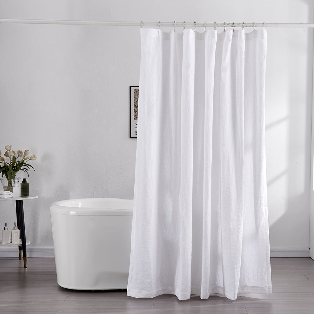 100% linen optic white shower curtain hanging over ceramic bathtub