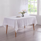 Corner angle optic white 100% linen tablecloth draped over a wooden dining table