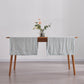 Side angle of pale blue linen table runners over wooden table
