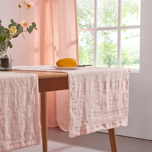 Close-up of peach table runners made from 100% linen draped over a wooden table